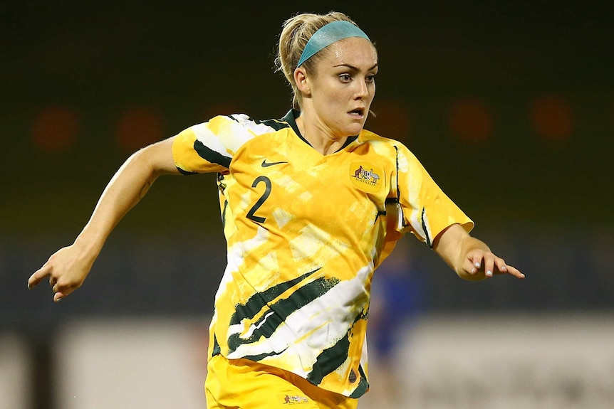 An Australian Matildas player dribbling the ball against Thailand.