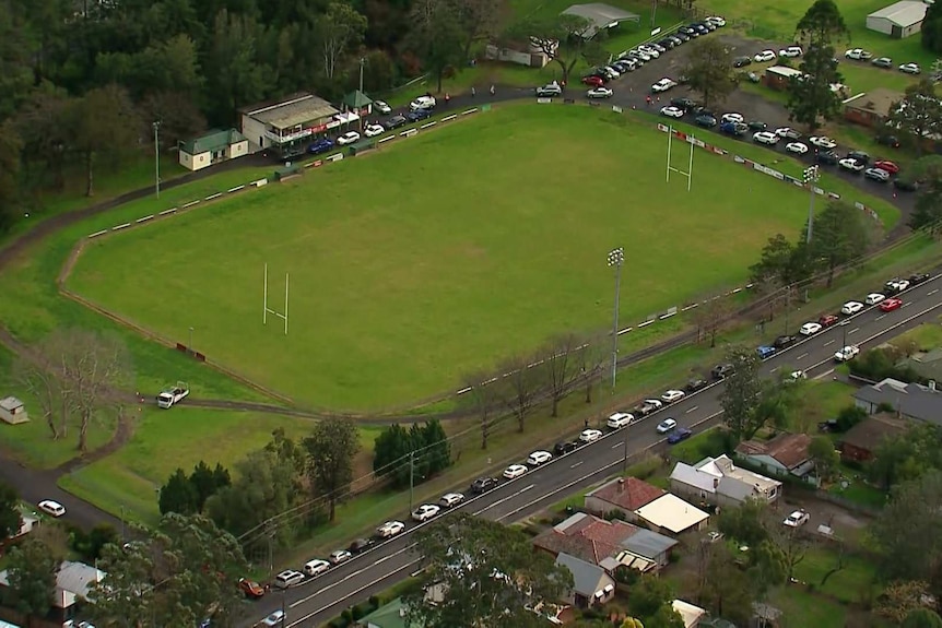 An aerial view of a long line of cars on a road.