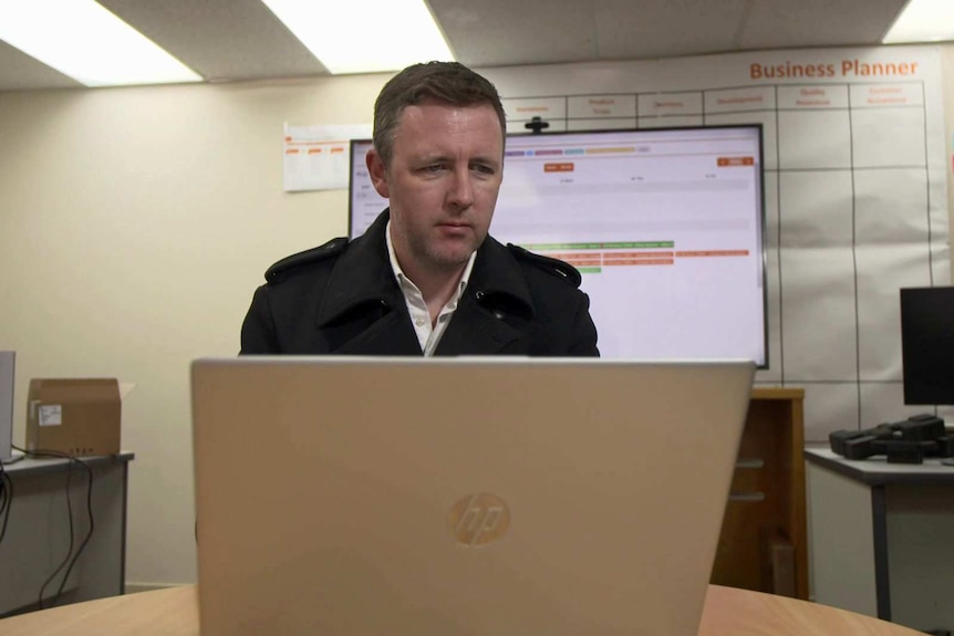 A man looks at a laptop screen.