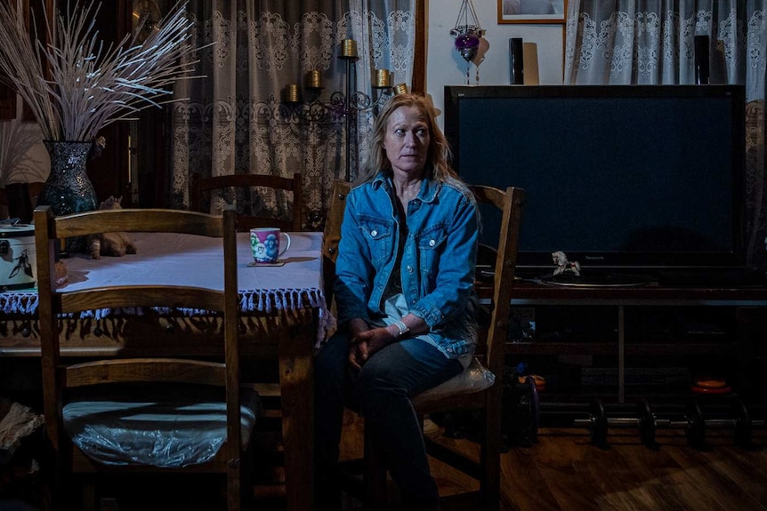 Donna Dickson sits in the dark in her home.