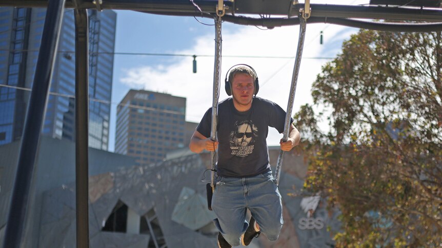 Melbourne man Aidan on the CSIRO Infinity Swing, which converts movement into clean energy.