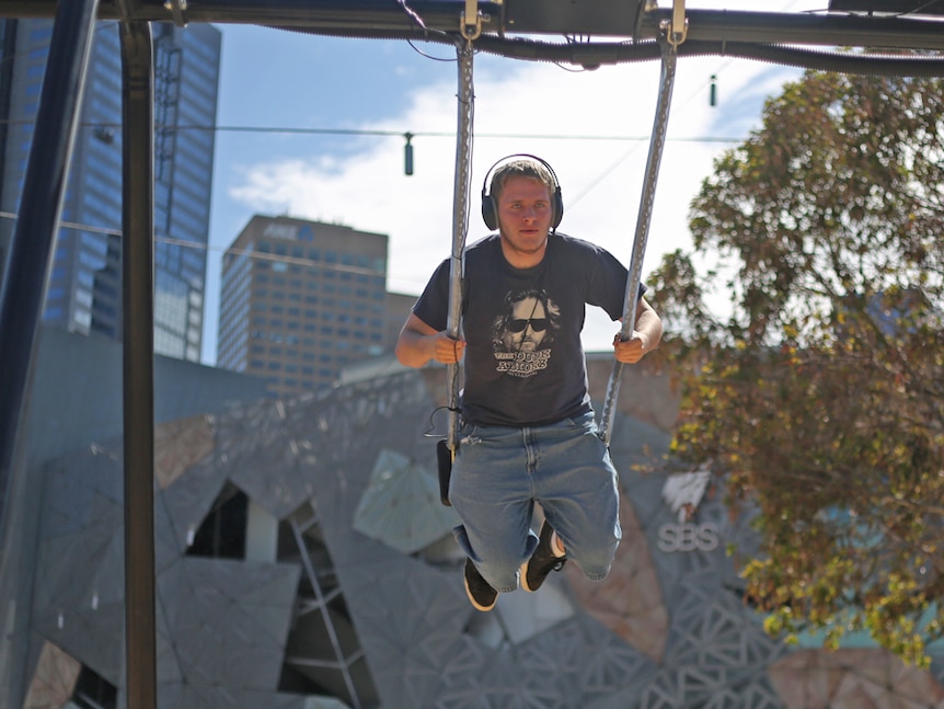Melbourne man Aidan on the CSIRO Infinity Swing, which converts movement into clean energy.