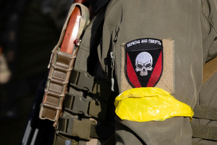 A patch containing the image of a skull, on the arm of a Ukrainian military uniform.