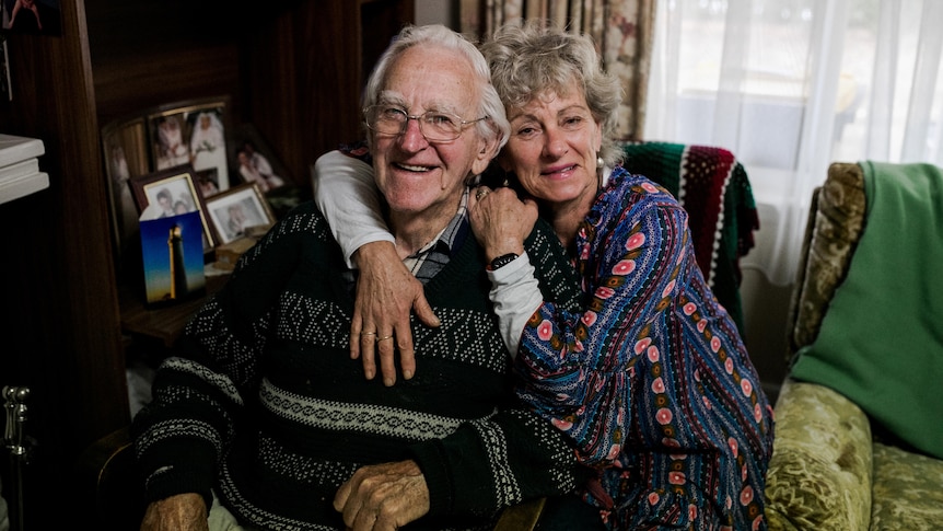 Pauline lovingly embraces her father Ted while looking at the camera.