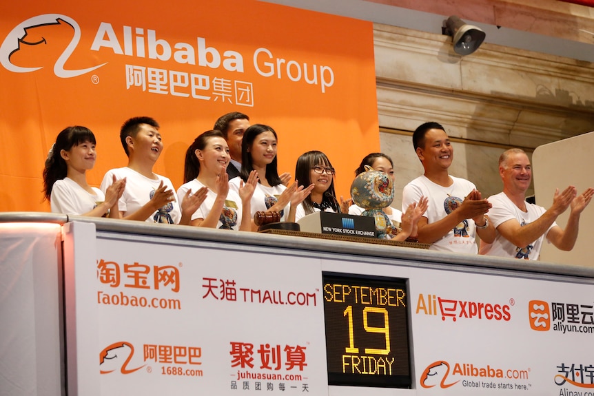 Los empleados de Alibaba aplauden cuando suena la campana de apertura de la Bolsa de Valores de Nueva York