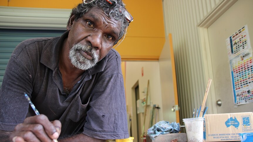 Wujal Wujal artist Clarence Ball painting in his workspace at the community's art centre