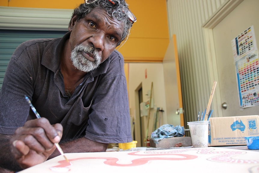 Wujal Wujal artist Clarence Ball painting in his workspace at the community's art centre