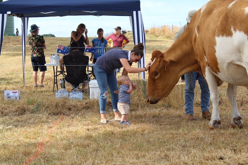 South East cow Big Moo stands next to people.