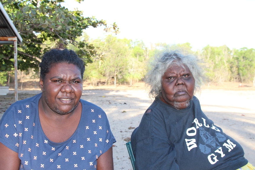 Two women smile to camera.