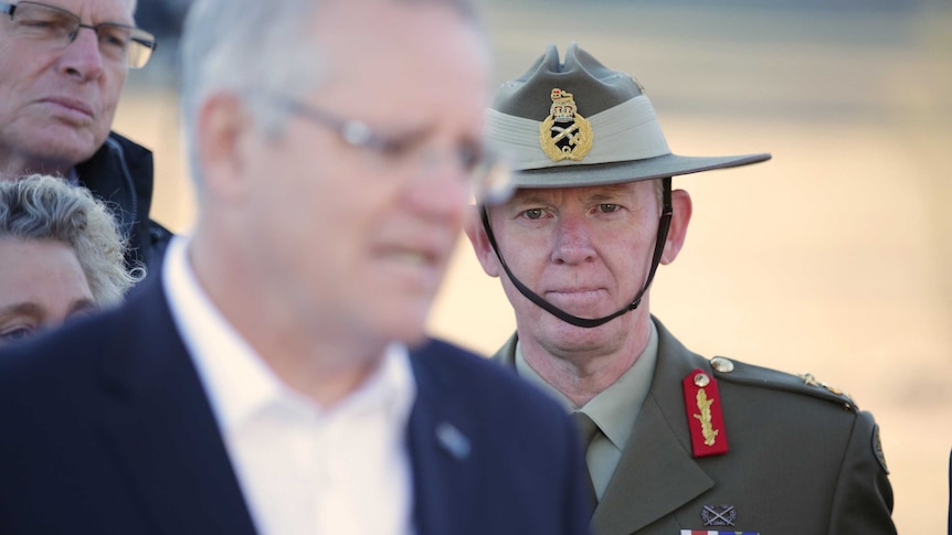 Stephen Day stands behind Scott Morrison at a press conference in a drought area