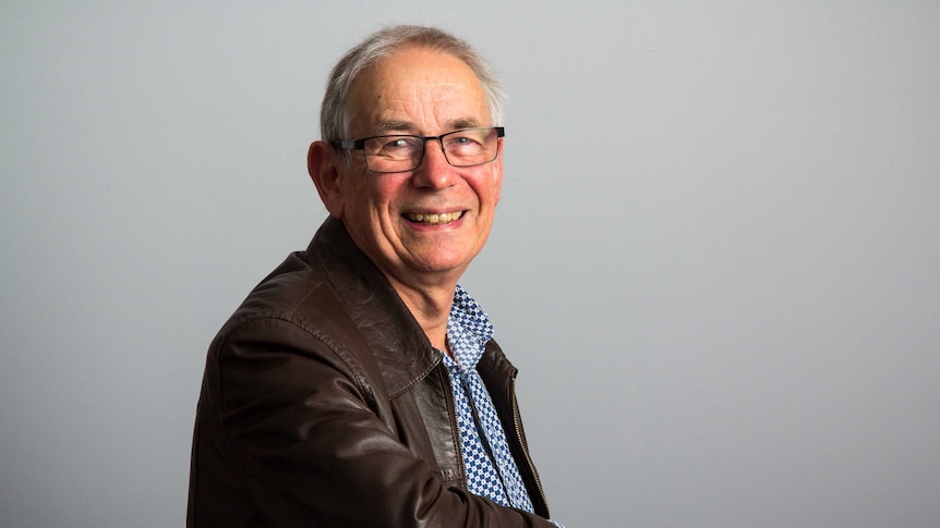 Dr Aidan Foy sits on a chair.