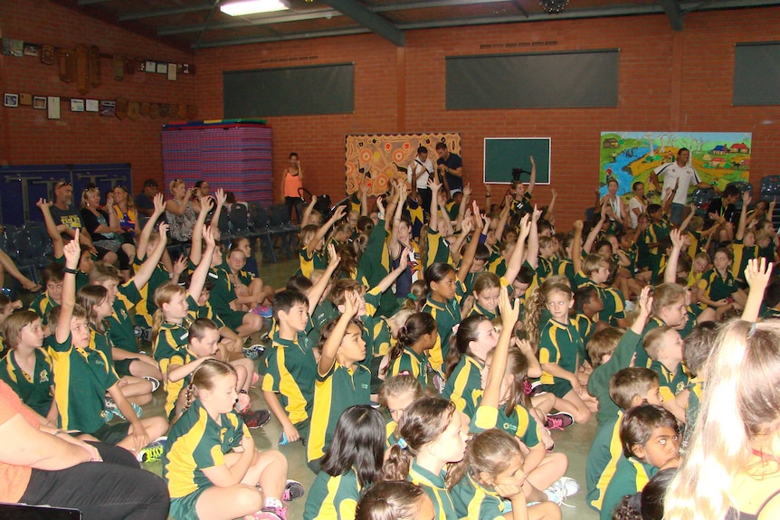 A photo of school children at Allendale Primary School with their hands up to ask questions of the West Coast Eagles