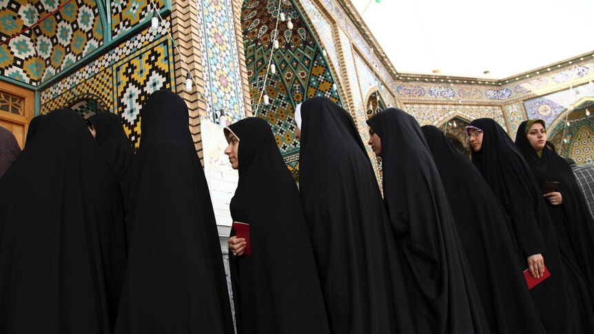 Women stand in line to vote during the Iranian presidential election at a mosque in Qom