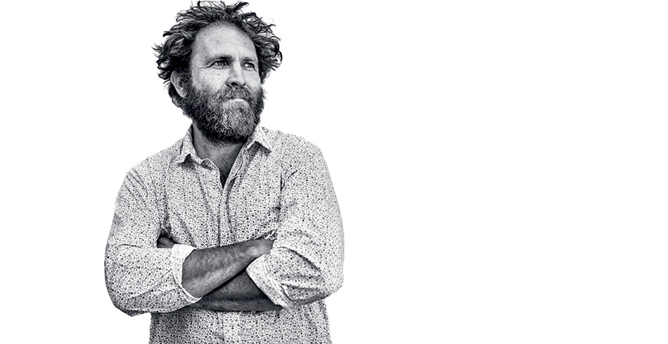 Saul Griffith standing in front of white background with arms crossed