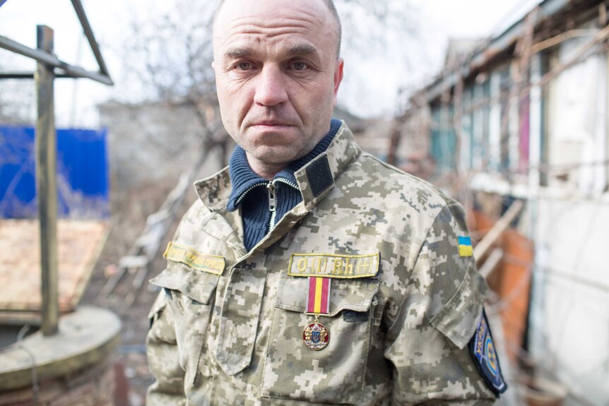 Ukrainian volunteer wears a medal.