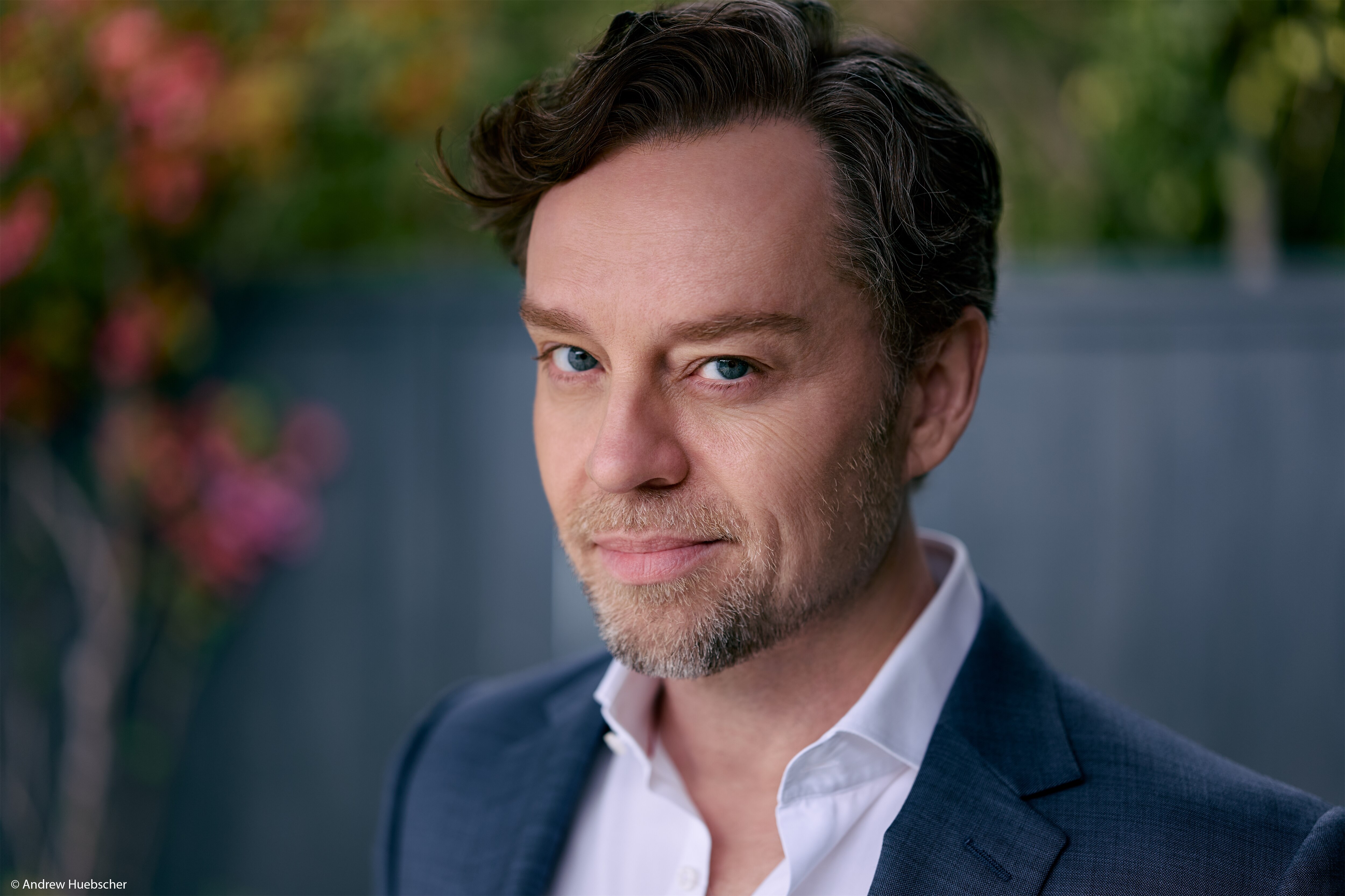 Headshot of Savage Garden singer Darren Hayes in a white collard shirt and blue blazer