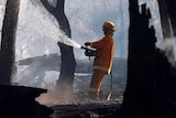 A CFA firefighter mops up a fire.