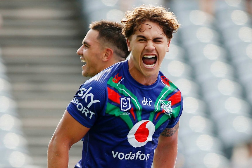 Rugby league player jumping in the air with excitement after the team scores a try