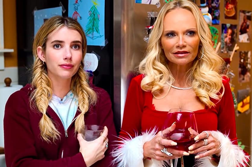 Emma Roberts and Kristin Chenoweth in a scene from Holidate. Chenoweth wears a red Christmas top with white fluff on the sleeves