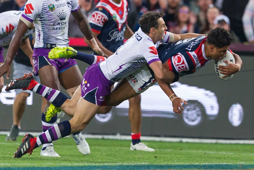 Latrell Mitchell carries Billy Slater over the line to score a try for the Roosters in the NRL grand final.