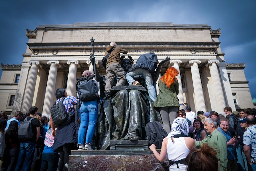 A group of people climbing on a statue 