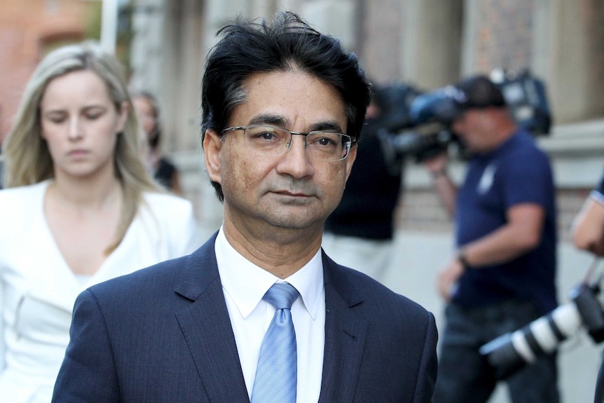 A tight mid shot of Lloyd Rayney walking outside court.