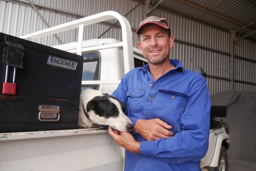 a man and his dog lean on a ute