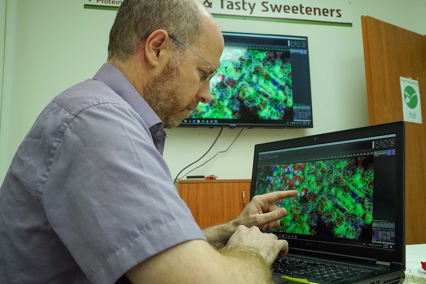 A man pointing to a genetic sequence on a computer screen