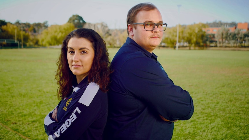 Defline and Hamish stand back to back on a soccer pitch in canberra.