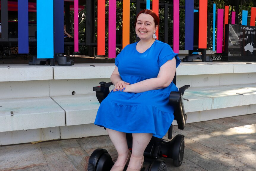 woman wearing a blue dress in a wheelchair