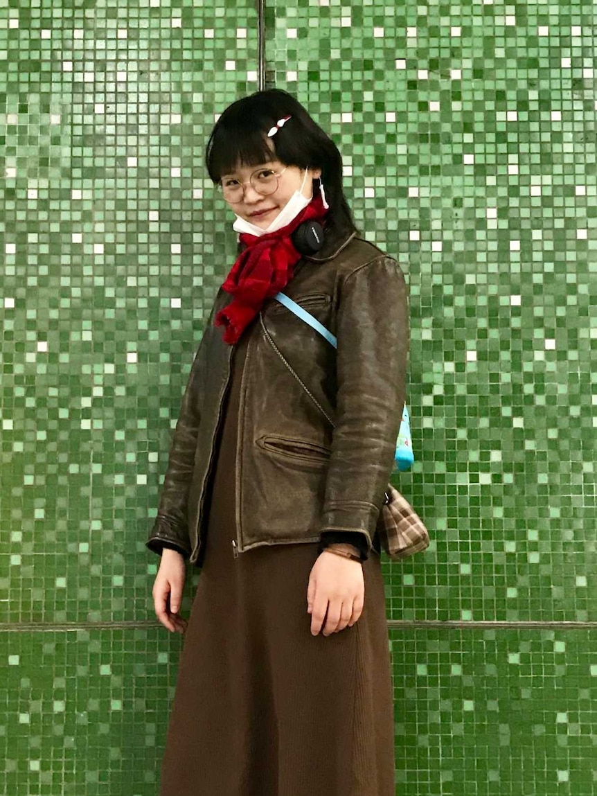 A woman in an art studio poses side on to the camera