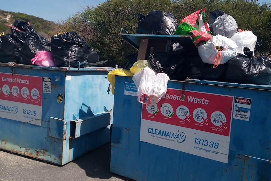 Rubbish bags overflowing large general waste bins