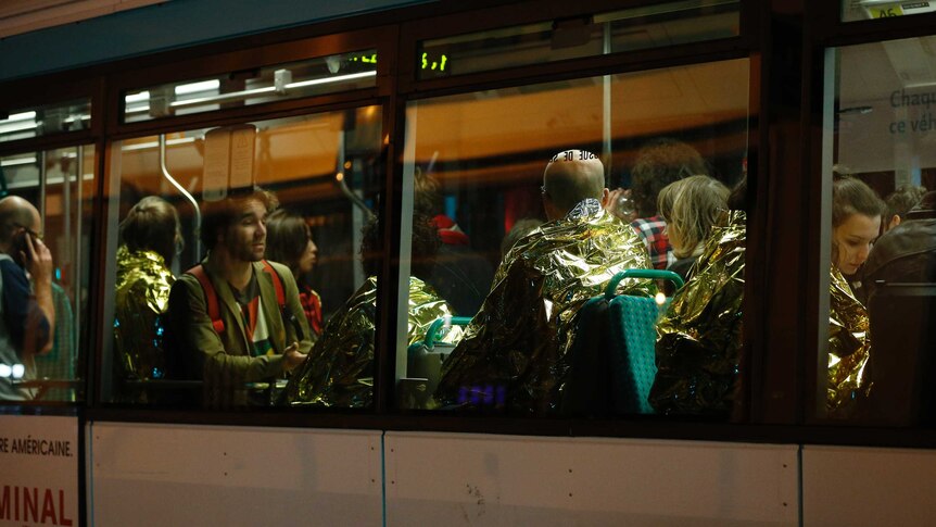 People are evacuated by bus, near the Bataclan concert hall