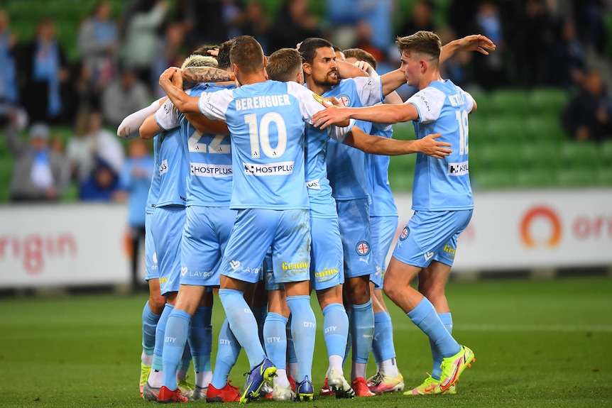 Football players in blue celebrate a goal.