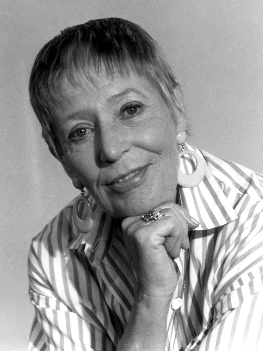 a black and white photo of a woman with short hair looking at the camera