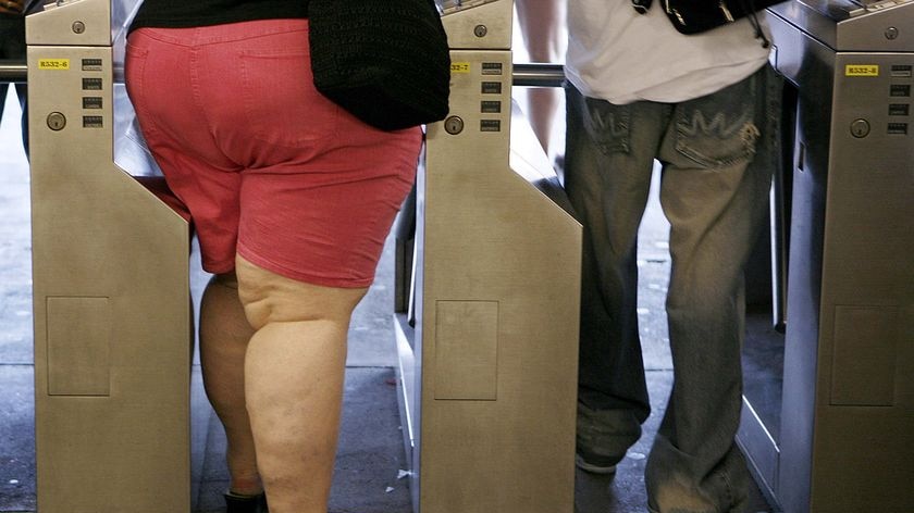 Subway riders walk through the turnstiles