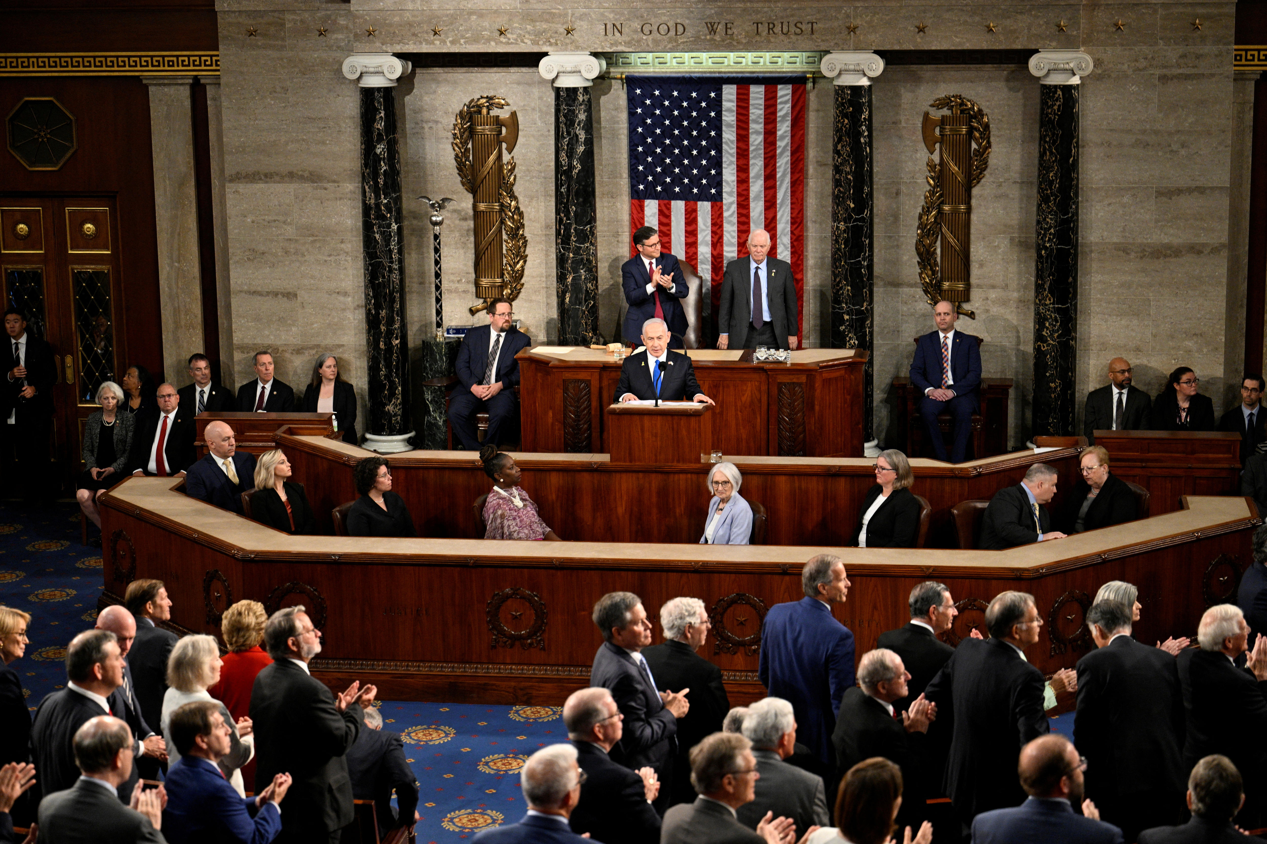Benjamin Netanyahu stands at a lectern in front of a United States flag