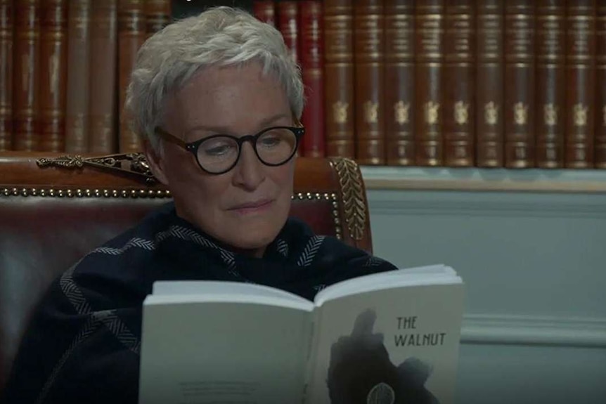 Glenn Close reading a book titled The Walnut in a scene from The Wife
