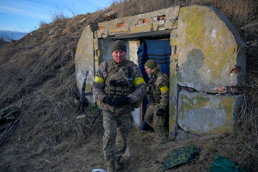Ukrainian servicemen take positions at the military airbase.