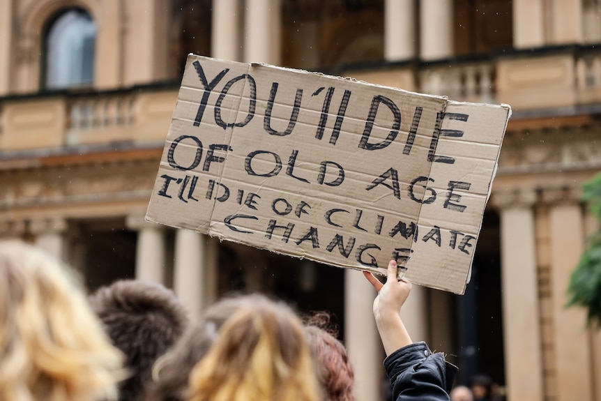 A sign reading 'You'll die of old age, I'll die of climate change' at a climate change rally in Sydney.