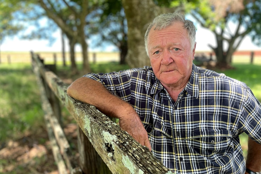 Brian Courtice looks at the camera, leaning on a fence post