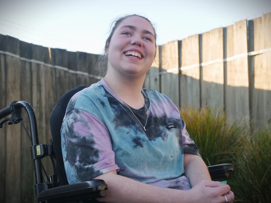 Shanika Thomas sitting in a wheelchair and smiling.