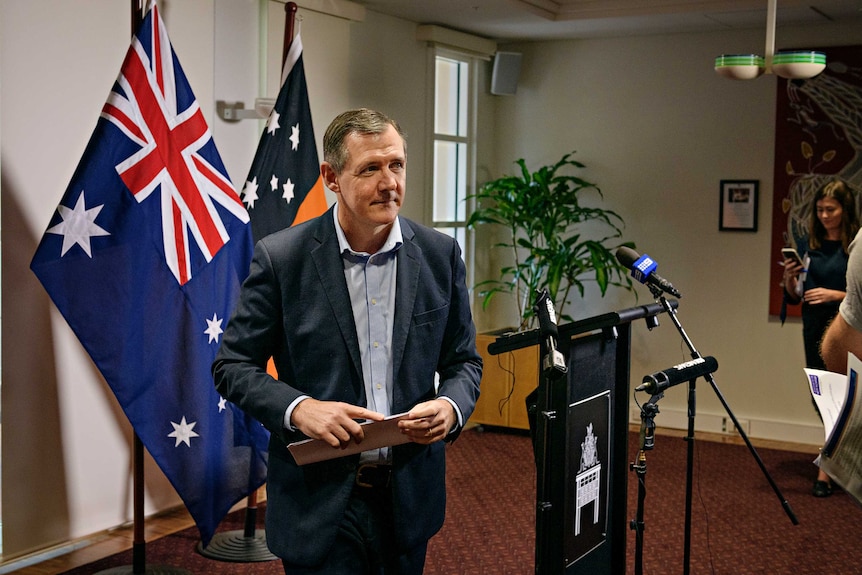 Michael Gunner exiting a room at the end of a press conference.