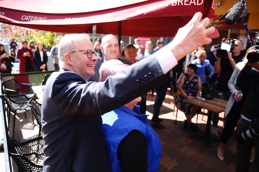Anthony Albanese takes a selfie with a woman while campaigning. 