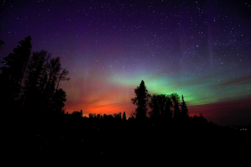The wildfires glow underneath The Northern Lights
