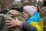 A local resident hugs Ukrainian serviceman