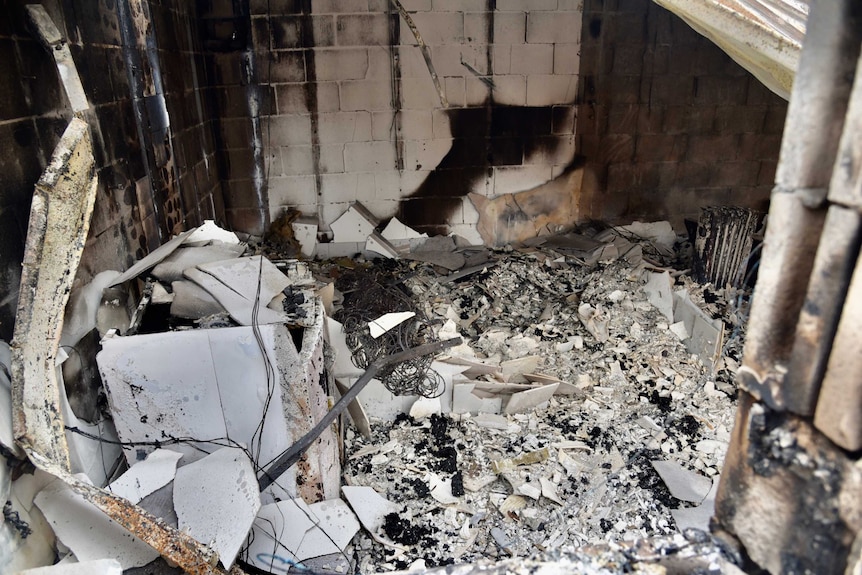 A pile of rubble in a burnt out home.