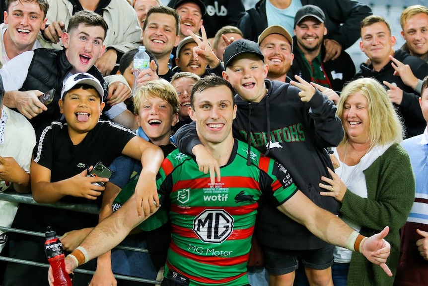 A man celebrates with family and friends after a rugby league match