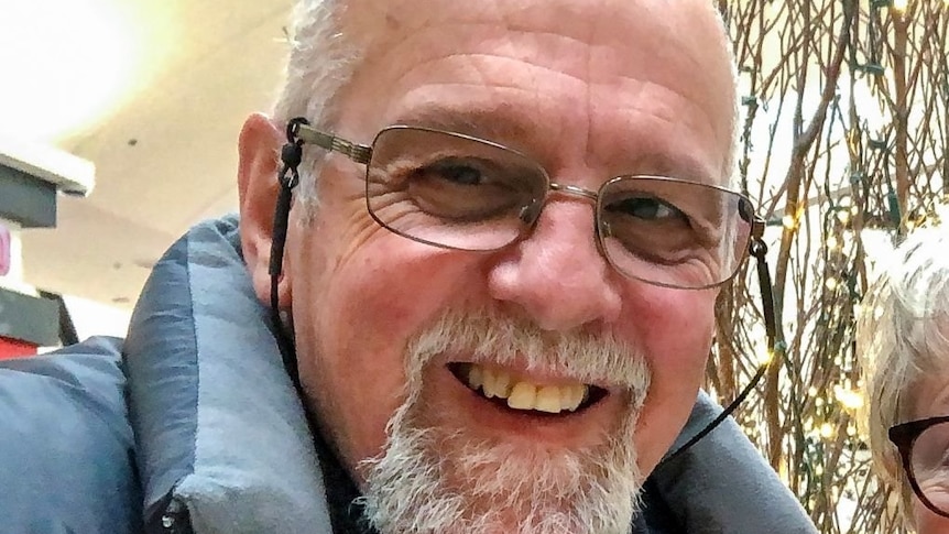 a man smiling in front of christmas decorations