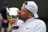 Dylan Alcott kisses the Wimbledon trophy